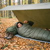 Sac de dormit Snugpak Sleeper Extreme în bivuac sub prelată, în pădure